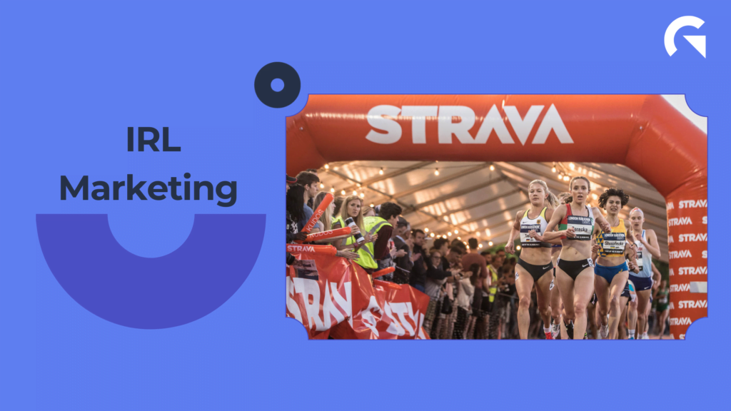 Image of racers crossing orange "STRAVA" inflatable finish line tunnel. 